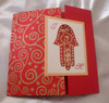 3 volets sur papier rouge, tissu arabesques or, main de fatema