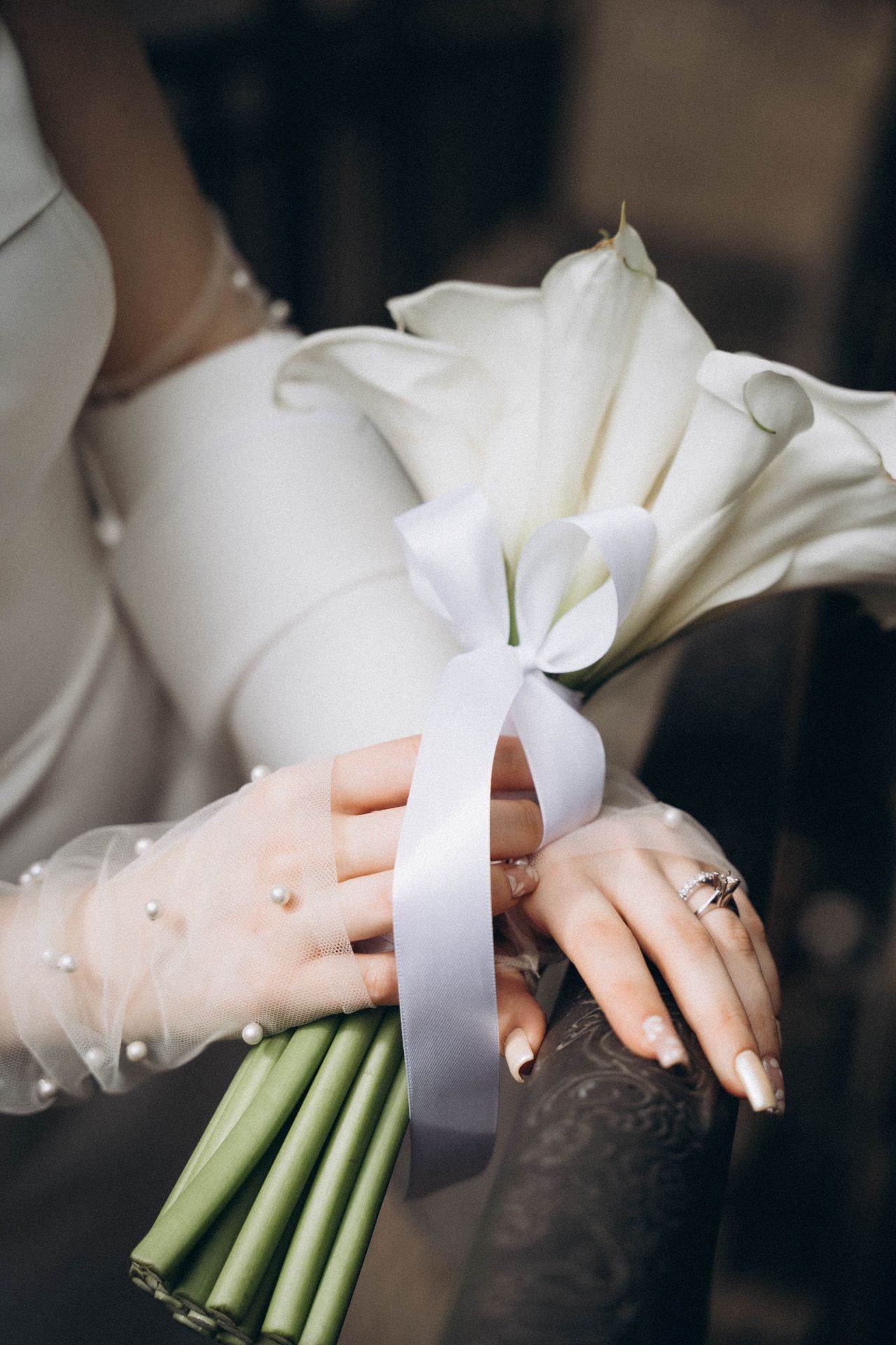 Bouquet d’arums blancs, alliances et manche perlée
