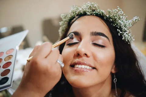 Une mariée se fait maquiller pendant ses préparatifs.
