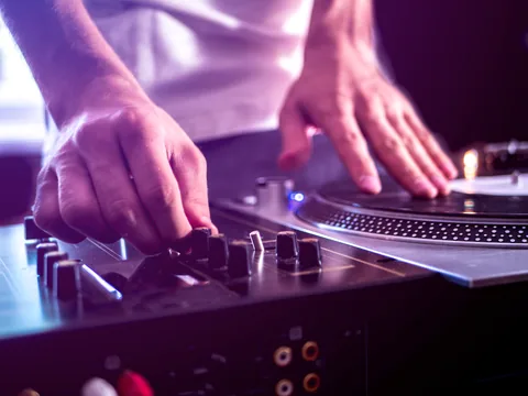 Les mains d’un DJ sur sa table de mixage.
