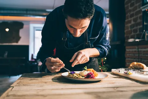 Un chef apporte la dernière touche au dressage d’une assiette.