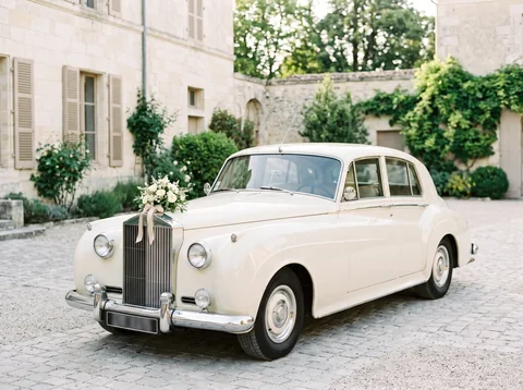 Illustration fictive : une voiture de cérémonie ivoire avec un bouquet blanc.