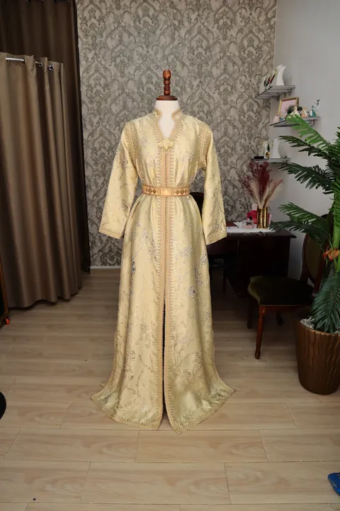 Caftan marocain ivoire et doré présenté sur un mannequin.